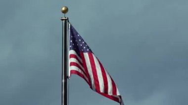 Arizona 'da bulutlu bir gökyüzüne doğru dalgalanan Amerikan bayrağı