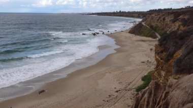 Malibu bölgesindeki Pasifik Okyanusu 'nun kumlu kıyılarında büyük dalgalar kıyıya vuruyor..