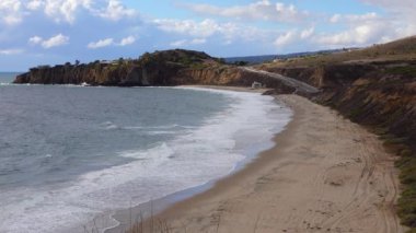 Malibu bölgesindeki Pasifik Okyanusu 'nun kumlu kıyılarında büyük dalgalar kıyıya vuruyor..