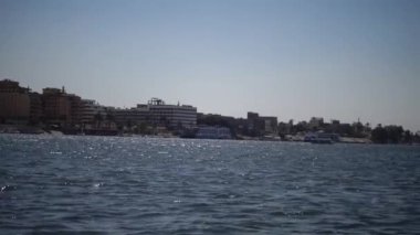 LUXOR, EGYPT - 5 Nisan 2019: Luxor 'daki Nil Nehri' ndeki turistik tekne, Mısır 'ın Nil Nehri' ndeki bir tekneden kıyıya bakıyor