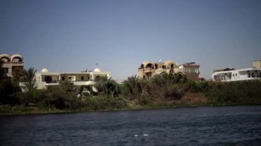 LUXOR, EGYPT - 5 Nisan 2019: Luxor 'daki Nil Nehri' ndeki turistik tekne, Mısır 'ın Nil Nehri' ndeki bir tekneden kıyıya bakıyor