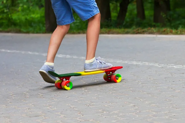 Roztomilé batole kluk baví s barevnými skateboard venku v parku — Stock fotografie