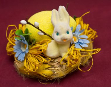 Çiçekler ve renkli Paskalya yumurtaları sepetle oturan sevimli beyaz tavşan