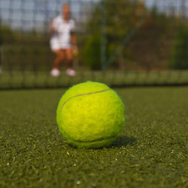 Tennisboll och silhuetten av tennisspelare — Stockfoto