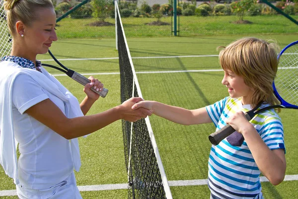 Jogadores de tênis apertar as mãos antes e depois do jogo de tênis. Na foto parece apertar as mãos cumprimentando uns aos outros de perto . — Fotografia de Stock