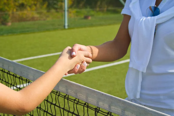 テニス選手は、テニスの試合の前後に手を振る。写真の握手を密接に互いに挨拶のように見えます. — ストック写真
