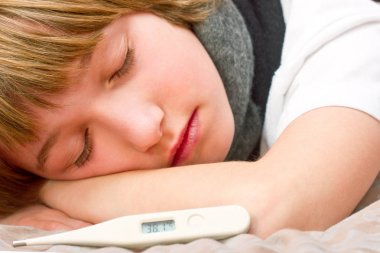 Dijital termometre ile yatakta yatarken küçük hasta çocuk