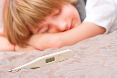 Dijital termometre ile yatakta yatarken küçük hasta çocuk