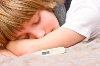 Dijital termometre ile yatakta yatarken küçük hasta çocuk