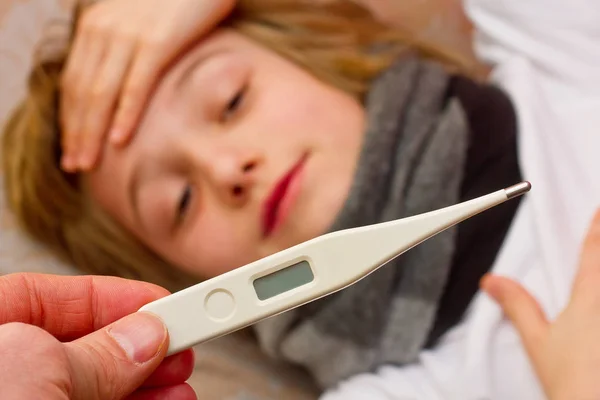 Yakın çekim termometre. Annesi hasta çocuğunu Sıcaklığı ölçme. Yatak ve anne holding termometre döşeme yüksek ateşle hasta çocuk. — Stok fotoğraf