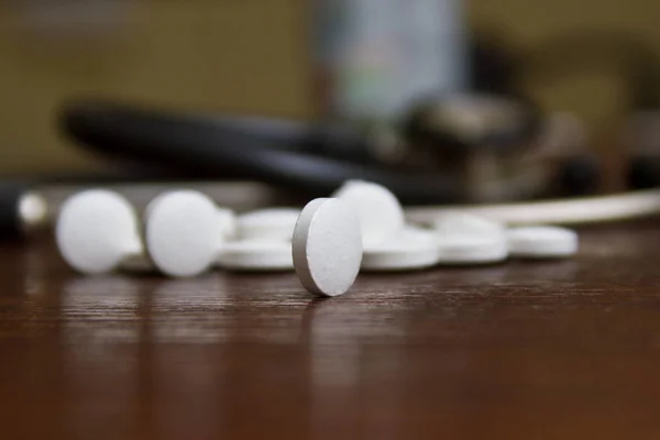 Herkömmliche weiße runde orale Medizin, auf einem hölzernen Hintergrund — Stockfoto