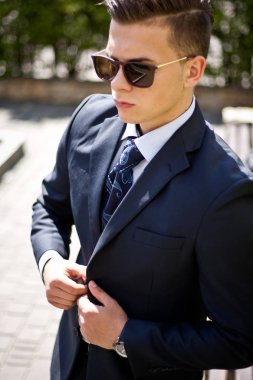 Ofiste çalışmak için sabah gidiş caddenin üzerinde yürüyen yakışıklı genç iş adamı. Genç profesyonel, kentsel yaşam tarzı