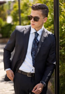 Ofiste çalışmak için sabah gidiş caddenin üzerinde yürüyen yakışıklı genç iş adamı. Genç profesyonel, kentsel yaşam tarzı