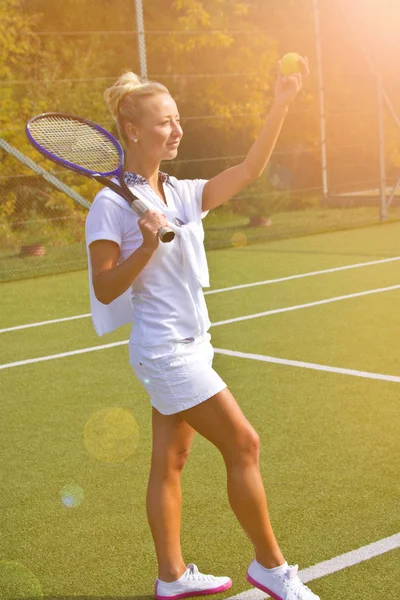 Chica feliz se para con raqueta en la cancha en el soleado día de verano — Foto de Stock