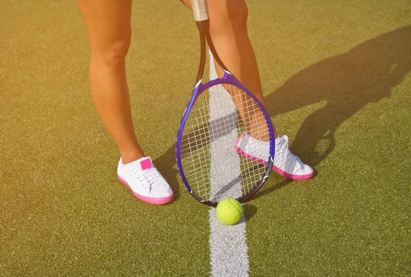 Goede benen staat met racket op rechter op zonnige zomerdag — Stockfoto