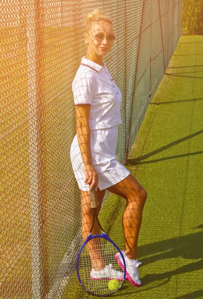 Happy girl stands with racket on court at sunny summer day — Stock Photo, Image