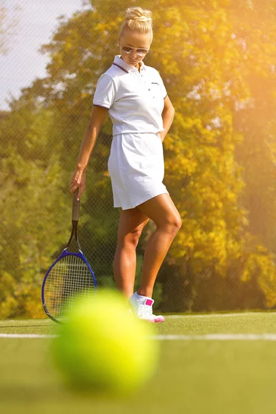 Bola de tênis na quadra de tênis com o jogador em segundo plano — Fotografia de Stock