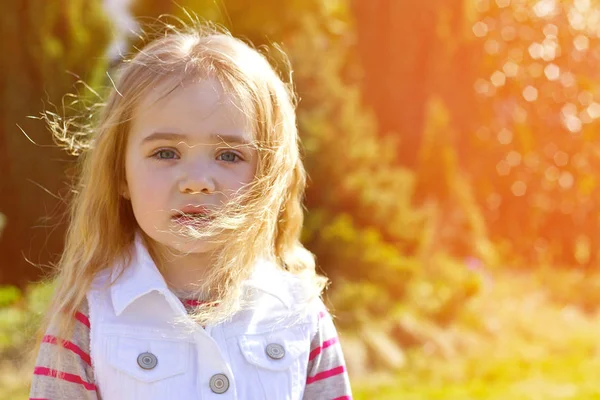 Емоційна маленька дівчинка з волоссям у сонячний весняний день — стокове фото