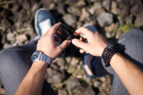 Ritratto di moda di giovane uomo d'affari bel modello uomo in abito di stoffa casual con accessori su mani, orologi in acciaio, jeans grigi e bracciali — Foto Stock