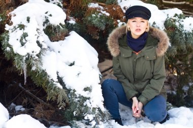 Kız oturdu bir kış ormanda sıcak giyinmiş