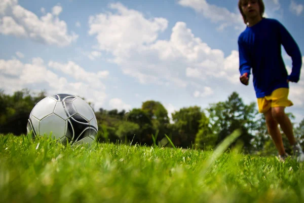 Piernas del jugador de fútbol pateando la pelota —  Fotos de Stock