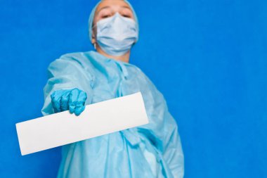 Genç doktor herhangi bir bilgi yazmak için beyaz boş kağıt gösteriyor.