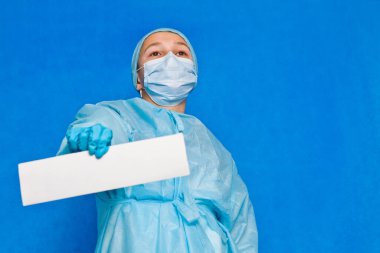 Genç doktor herhangi bir bilgi yazmak için beyaz boş kağıt gösteriyor.