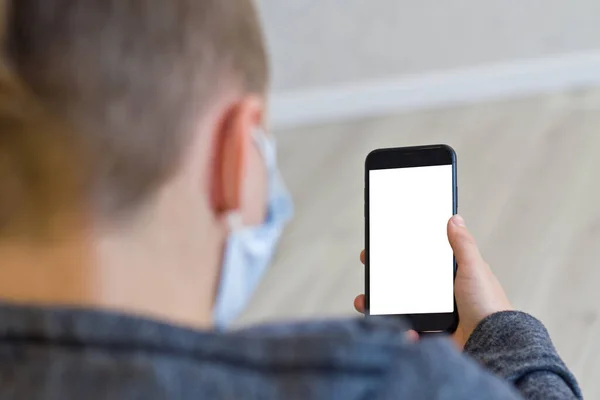 Junger Mann Mit Gesichtsmaske Hält Handy Mit Leerem Bildschirm — Stockfoto