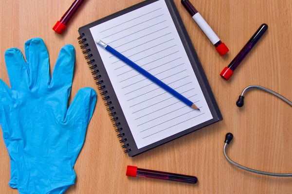 Notizbuch Mit Vakuumröhren Zur Blutentnahme Und Gummihandschuhen Auf Einem Holztisch — Stockfoto