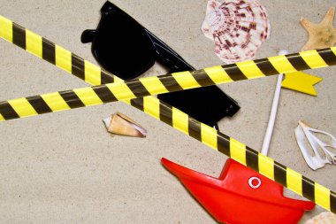 Bariyer bandı - karantina, tecrit, giriş yasağı yaz kompozisyonu. Güneş gözlükleri, deniz kabukları, deniz kırmızı yıldızı, pastel sarı arka planda tekne..