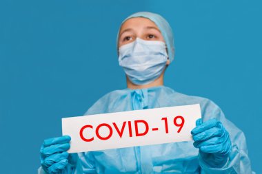 Genç doktor covid-19 yazan bir tabela gösteriyor..