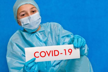 Genç doktor covid-19 yazan bir tabela gösteriyor..