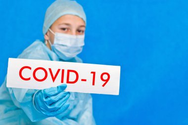 Genç doktor covid-19 yazan bir tabela gösteriyor..