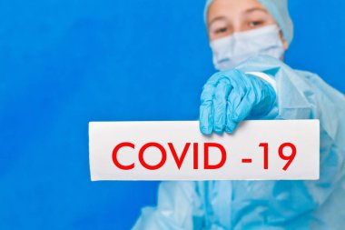 Genç doktor covid-19 yazan bir tabela gösteriyor..
