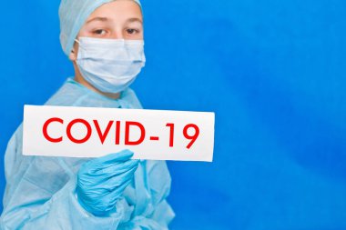Genç doktor covid-19 yazan bir tabela gösteriyor..