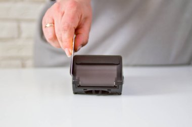 Kadın eli, malların parasını ödemek için terminalde bir kart tutuyor..