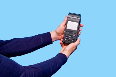 Kredi kartı ödemelerini işlemek ve almak için kablosuz, modern bir banka ödeme terminali tutan bir adamın kesilmiş fotoğrafı..