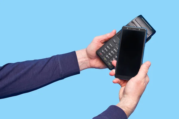 青色の背景にスマートフォンで非接触決済端末を使用した男性の手 — ストック写真