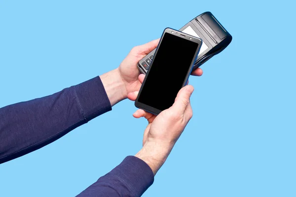 Männliche Hand Mit Kontaktlosem Zahlungsterminal Mit Smartphone Auf Blauem Hintergrund — Stockfoto