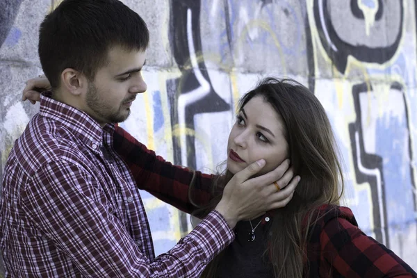 Young guy hugs his girlfriend near graffiti wall. Love story. St.Valentine's day story — Stock Photo, Image