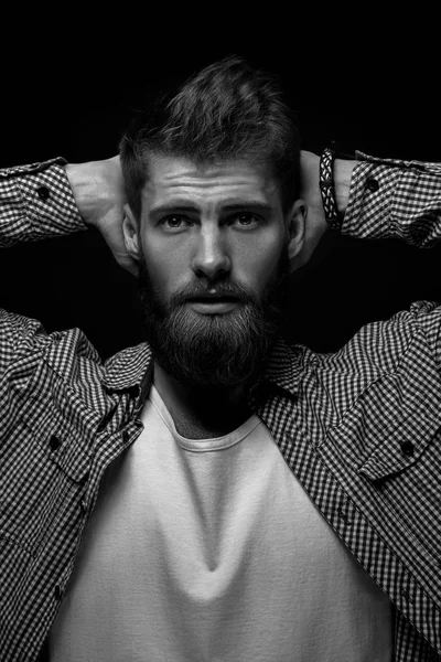 Black and white portrait of brutal bearded man holding his hands — Stock Photo, Image