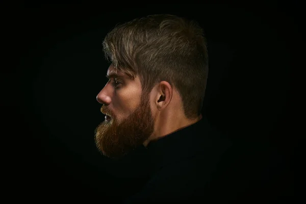 Close up image of serious brutal bearded man on dark background Confident and dramatic concept — Stock Photo, Image