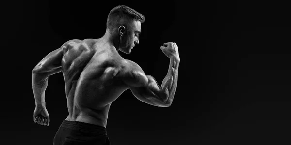 Costas fortes de um homem musculoso atlético flexionando os braços — Fotografia de Stock