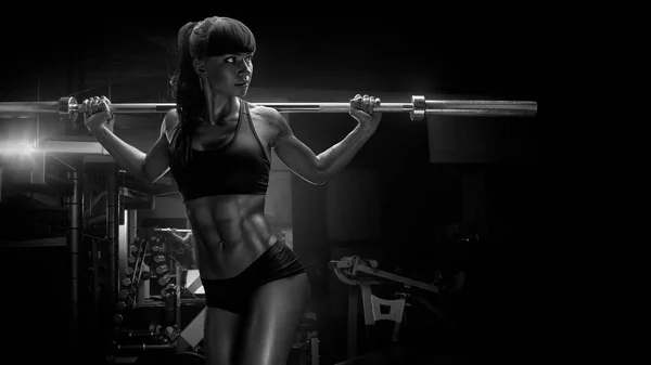Black and white photo of fit young woman in great shape lifting — Stock Photo, Image