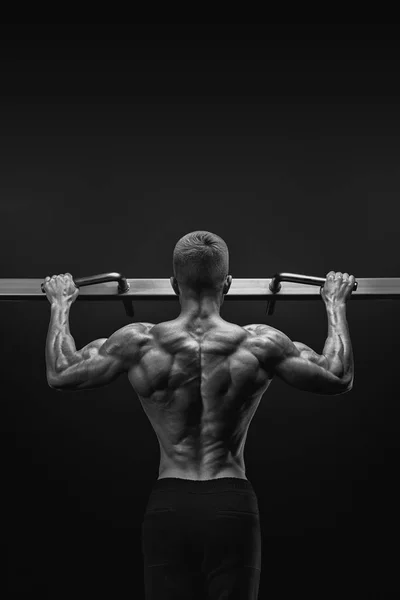 Power muscular bodybuilder guy doing pullups in gym. Fitness man — Stock Photo, Image