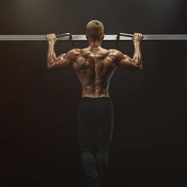 Power muskelbyggaren killen gör pull ups i gymmet. Träningsmänniska — Stockfoto