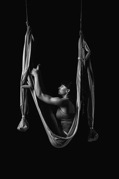 Ung kvinna sträcker sig medan gör anti-gravitation aerial yoga — Stockfoto