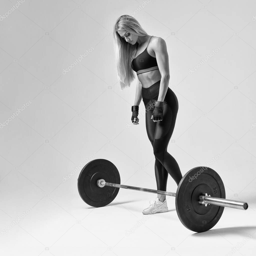 Fit young woman lifting barbell