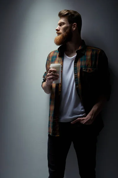Уверенный бородатый мужчина держит чашку кофе — стоковое фото