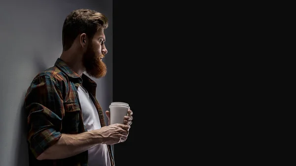 Bearded man drinking cappuccino coffee to go